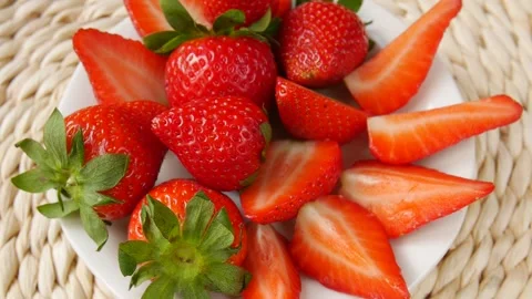 Sliced strawberries on a plate. Video stock 245681503