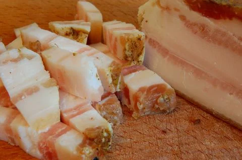 Sliced tasty bacon of salty pork on a chopping board close up Stock Photos