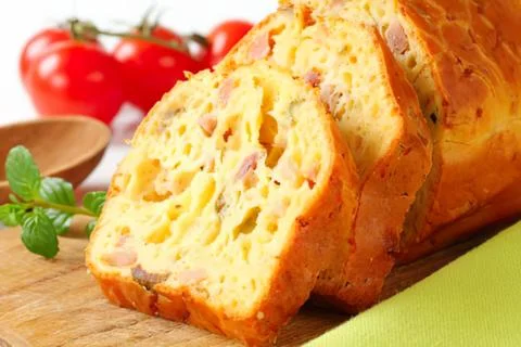 Sliced tomato and herb bread loaf on wooden table Stock Photos