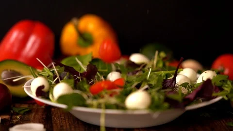 Sliced tomato being added to a plate of salad Video stock 105111183