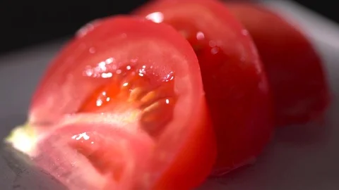 Sliced tomatoes on the black background slow motion, macro Stock Footage 76200384