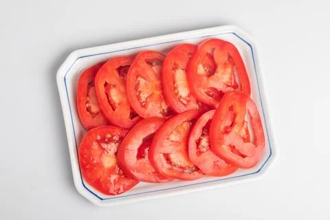 Sliced tomatoes in a plate on a white background Stock Photos