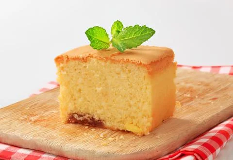 Sliced vanilla cake with mint leaf garnish Stock Photos