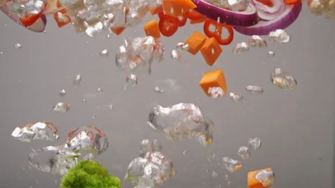 Sliced vegetables of different colors are boiled in boiling water, slow motion Stock Footage 124306522