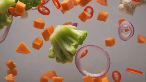 Sliced vegetables mix colors floating in the water. Vidéo 124309806