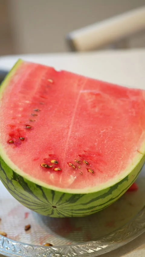 Sliced watermelon piece on a silver platter with background blur. Stock Footage 341562828