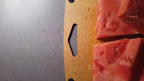Sliced watermelon spread out on a cutting board, panning slowly right across Stock Footage 113713451