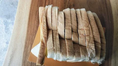 Sliced white bread on a rustic wooden table background 库存照片