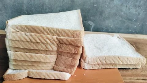 Sliced white bread on a rustic wooden table background 库存照片