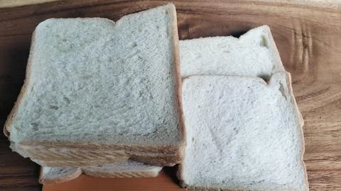 Sliced white bread on a rustic wooden table background 库存照片
