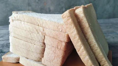 Sliced white bread on a rustic wooden table background 库存照片