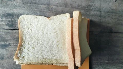Sliced white bread on a rustic wooden table background 库存照片
