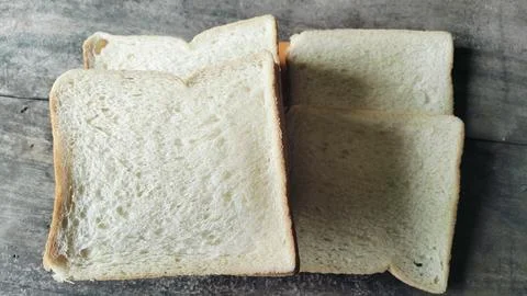Sliced white bread on a rustic wooden table background 库存照片