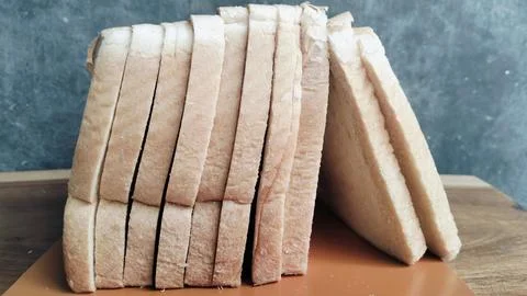 Sliced white bread on a rustic wooden table background 库存照片