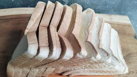 Sliced white bread on a rustic wooden table background 库存照片