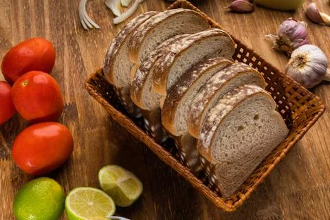 Sliced white bread with wheat flour on a wooden table. Chamado Po de forma Stock Photos