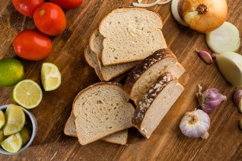 Sliced white bread with wheat flour on a wooden table. Chamado Po de forma Stock Photos