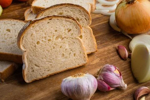 Sliced white bread with wheat flour on a wooden table. Chamado Po de forma Stock Photos
