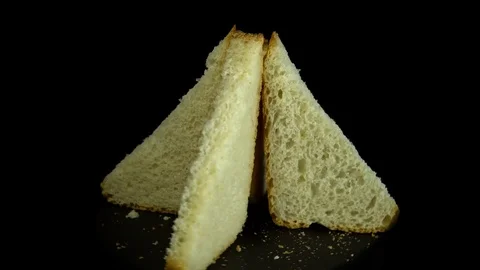 Sliced white wheat bread rotates against a black background, circular motion. 스톡 동영상 83247955