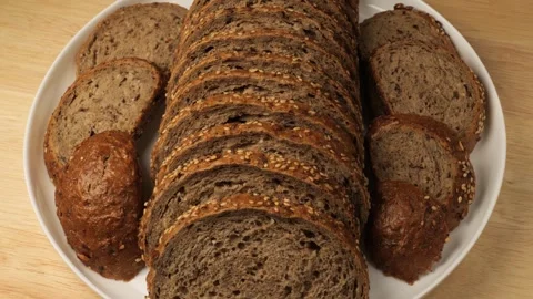 Sliced whole grain bread rotating on a plate Stock Footage 345530323
