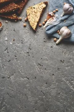 Sliced whole wheat bread, chickpea and garlic on the grey concrete backdrop Stock Photos