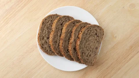 Sliced whole wheat bread rotating on a plate Stock Footage 342436867