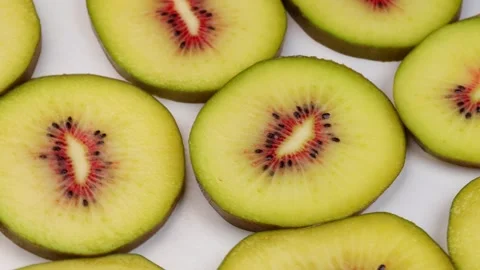 Sliced yellow kiwi fruit rotating in circle with red-centered flesh Stock Footage 318897802