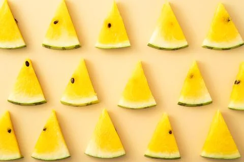 Sliced yellow watermelon pattern flat lay on pastel yellow table background. Stock Photos