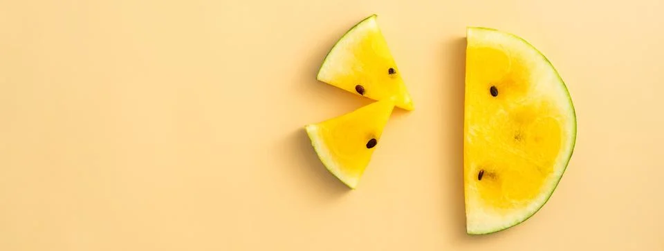 Sliced yellow watermelon pattern flat lay on pastel yellow table background. Stock Photos