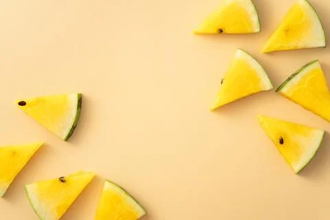 Sliced yellow watermelon pattern flat lay on pastel yellow table background. Stock Photos