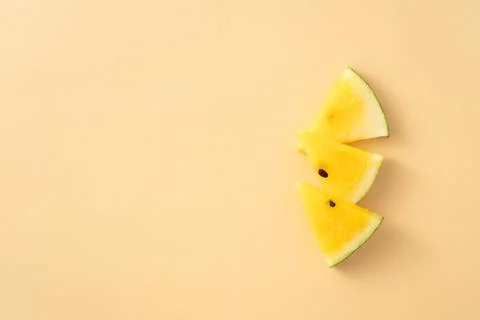 Sliced yellow watermelon pattern flat lay on pastel yellow table background. Stock Photos