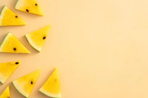Sliced yellow watermelon pattern flat lay on pastel yellow table background. Stock Photos