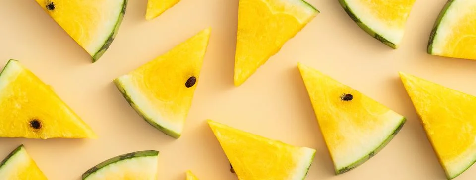 Sliced yellow watermelon pattern flat lay on pastel yellow table background. Stock Photos
