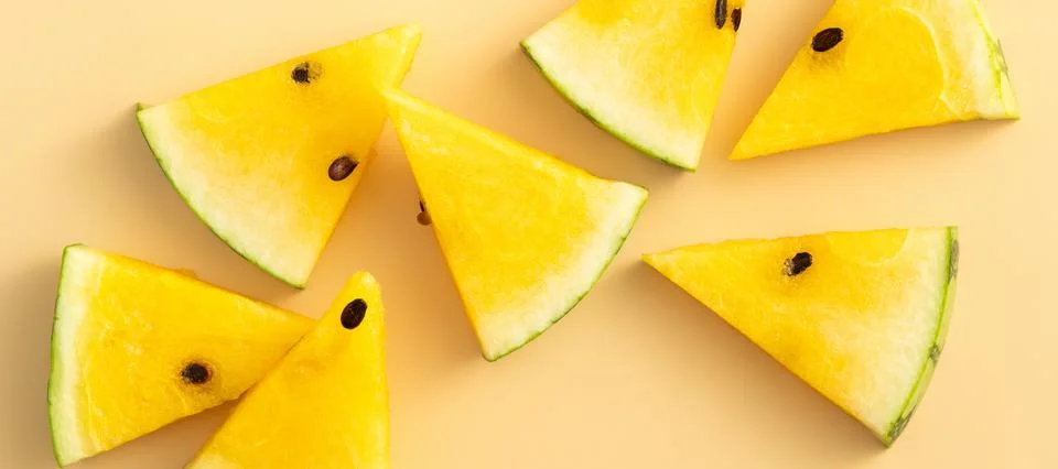 Sliced yellow watermelon pattern flat lay on pastel yellow table background. Stock Photos