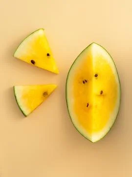 Sliced yellow watermelon pattern flat lay on pastel yellow table background. Stock Photos