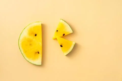 Sliced yellow watermelon pattern flat lay on pastel yellow table background. Stock Photos