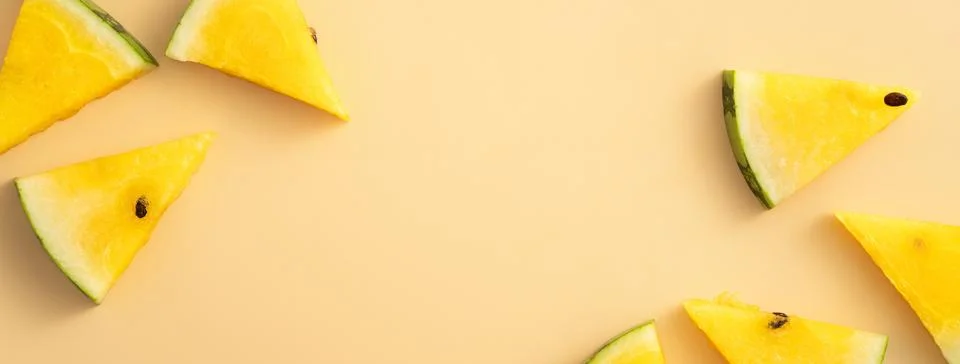 Sliced yellow watermelon pattern flat lay on pastel yellow table background. 写真素材