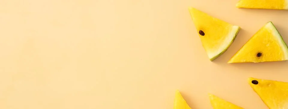 Sliced yellow watermelon pattern flat lay on pastel yellow table background. Stock Photos