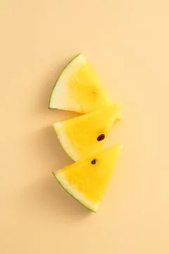 Sliced yellow watermelon pattern flat lay on pastel yellow table background. Stock Photos