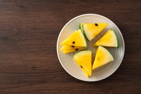 Sliced yellow watermelon pattern flat lay on wooden table background. Stockfoto's