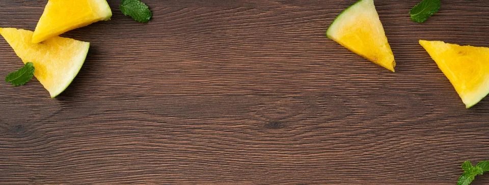 Sliced yellow watermelon pattern flat lay on wooden table background. Stock Photos