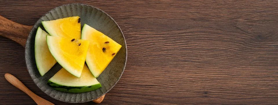 Sliced yellow watermelon pattern flat lay on wooden table background. Foto stock
