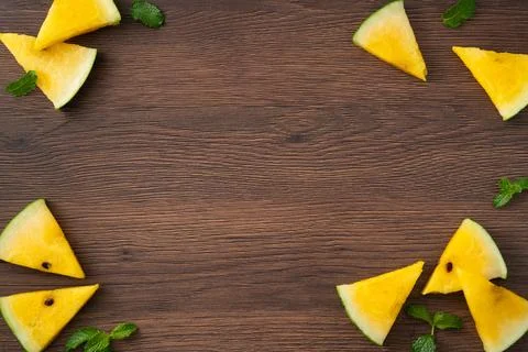 Sliced yellow watermelon pattern flat lay on wooden table background. Stockfoto's