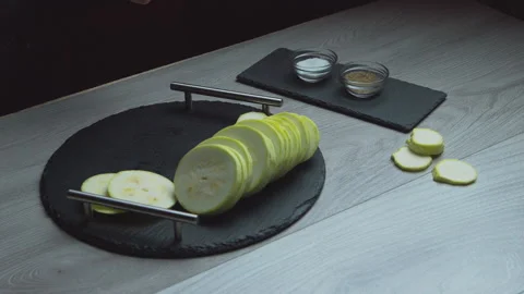 Sliced ​​zucchini fall slowly on a plate. Food at home Stock Footage 135236439