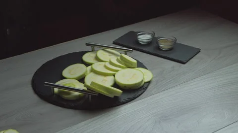 Sliced ​​zucchini fall slowly on a plate. Food at home Stock Footage 135236478