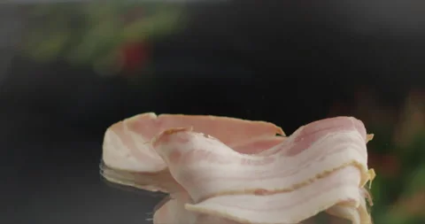 Slices of bacon fall on a mirror surface Stock Footage 196971368