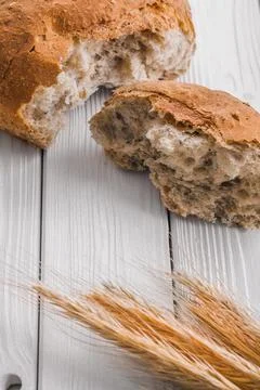 Slices of bread and wheat ears on old white wooden boards 写真素材