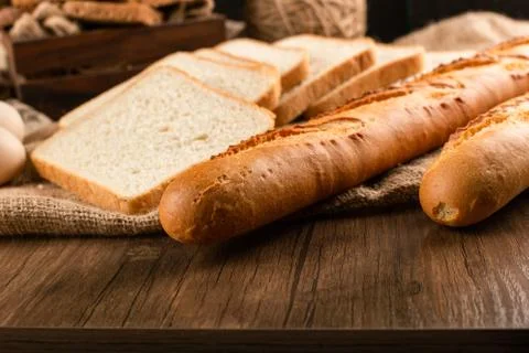 Slices of bread with baguette on table Stock Photos