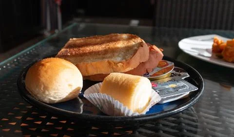Slices of bread, bun, jam roll and butter for breakfast 写真素材