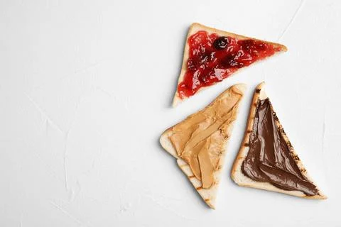 Slices of bread with different spreads on white table, flat lay. Space for te Foto stock